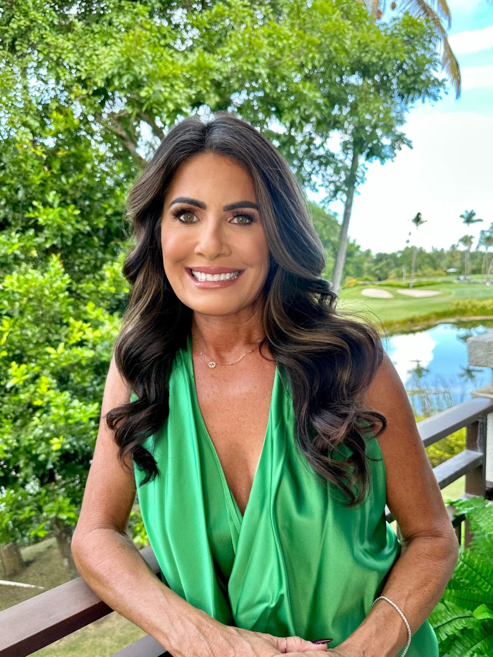 A woman in green dress smiling for the camera.